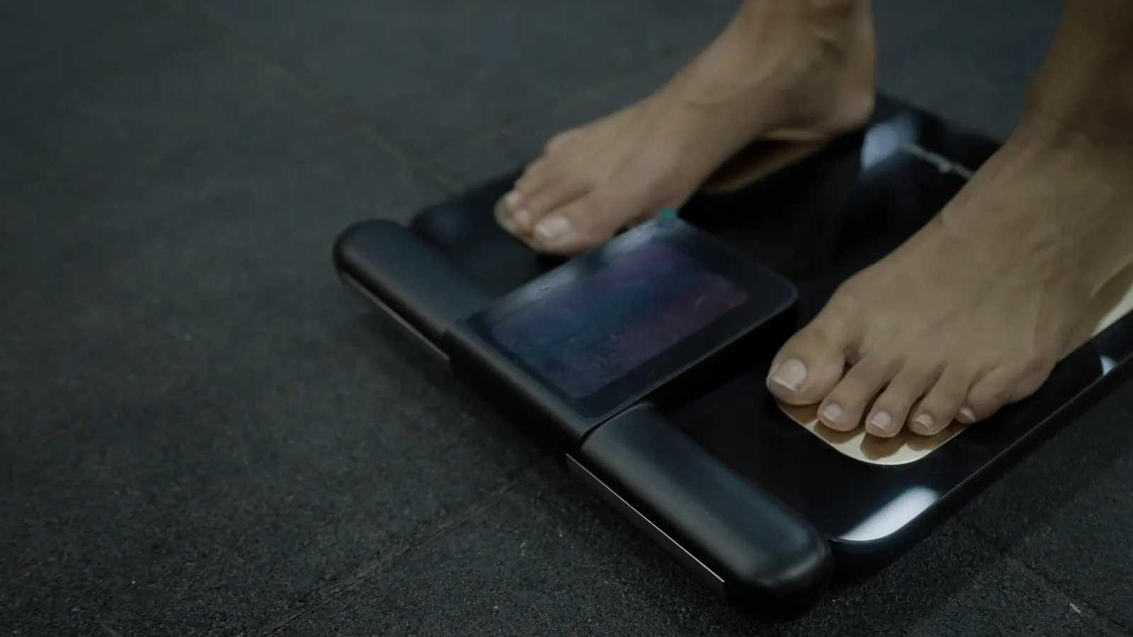Athlete standing barefoot on a segmental body-composition analyser