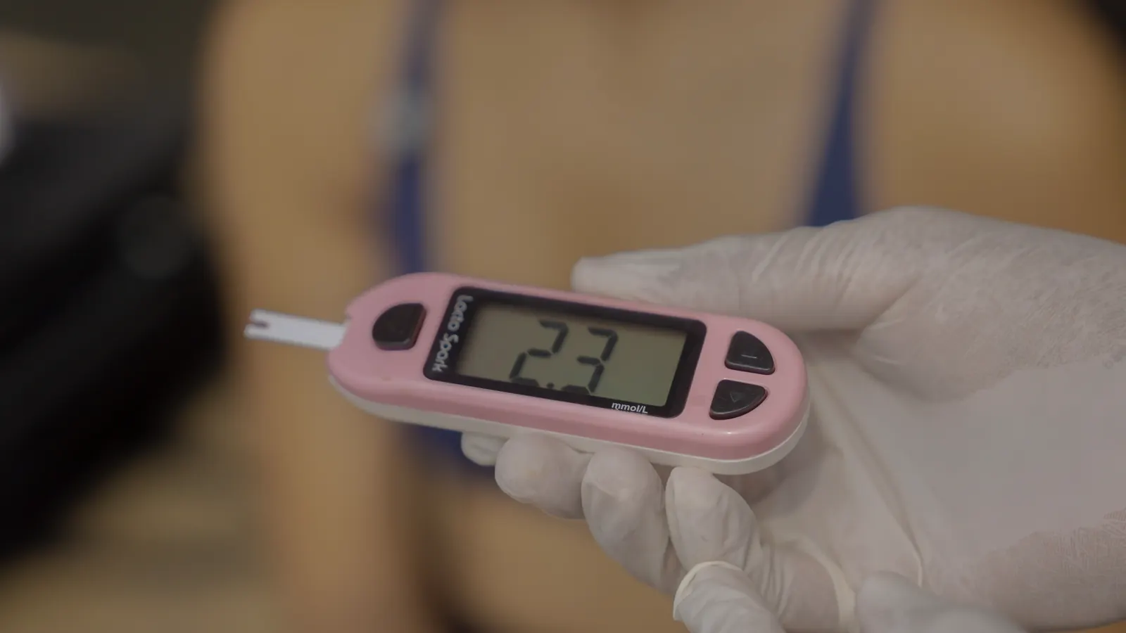 Blood-lactate meter reading 2.3 held in a gloved hand