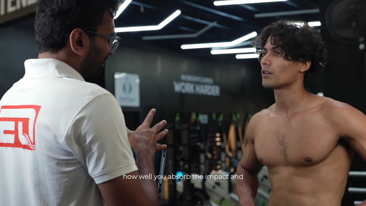 EvoQuest coach explaining force-plate results to an athlete in the gym